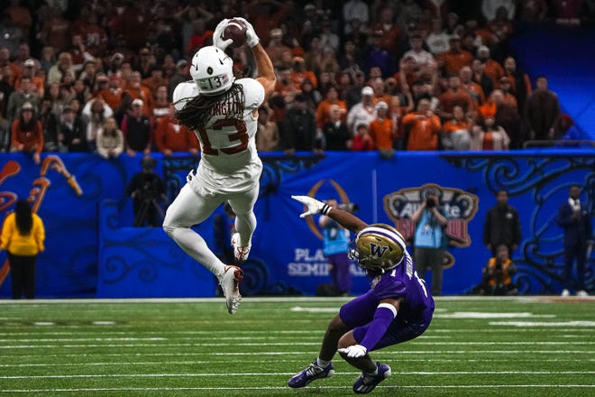 Texas Longhorns wide receiver Jordan Whittington (13) makes a catch over Washington cornerback Jabbar Muhammad (1) during the Sugar Bowl College Football Playoff semifinals game at the Caesars Superdome on Monday, Jan. 1, 2024 in New Orleans, Louisiana.